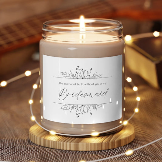 A picture of our 9 Oz Soy Candle with the label that says The Aisle wont be lit without you as my Bridesmaid. There are Beautiful floral border drawing on the top and bottom of the saying, in simple and elegant black ink color.