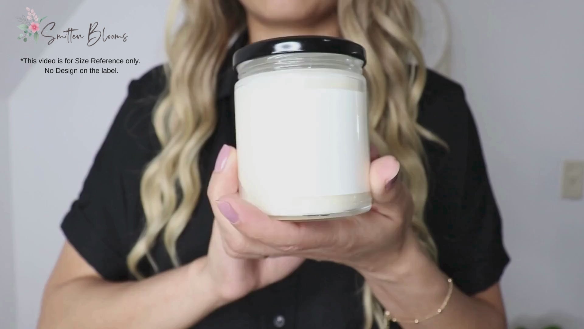A video of a woman showing our 9 Oz soy wax candle for size reference only. There is design on this label. This video is to give customers an idea of the real life size of the candle jars.