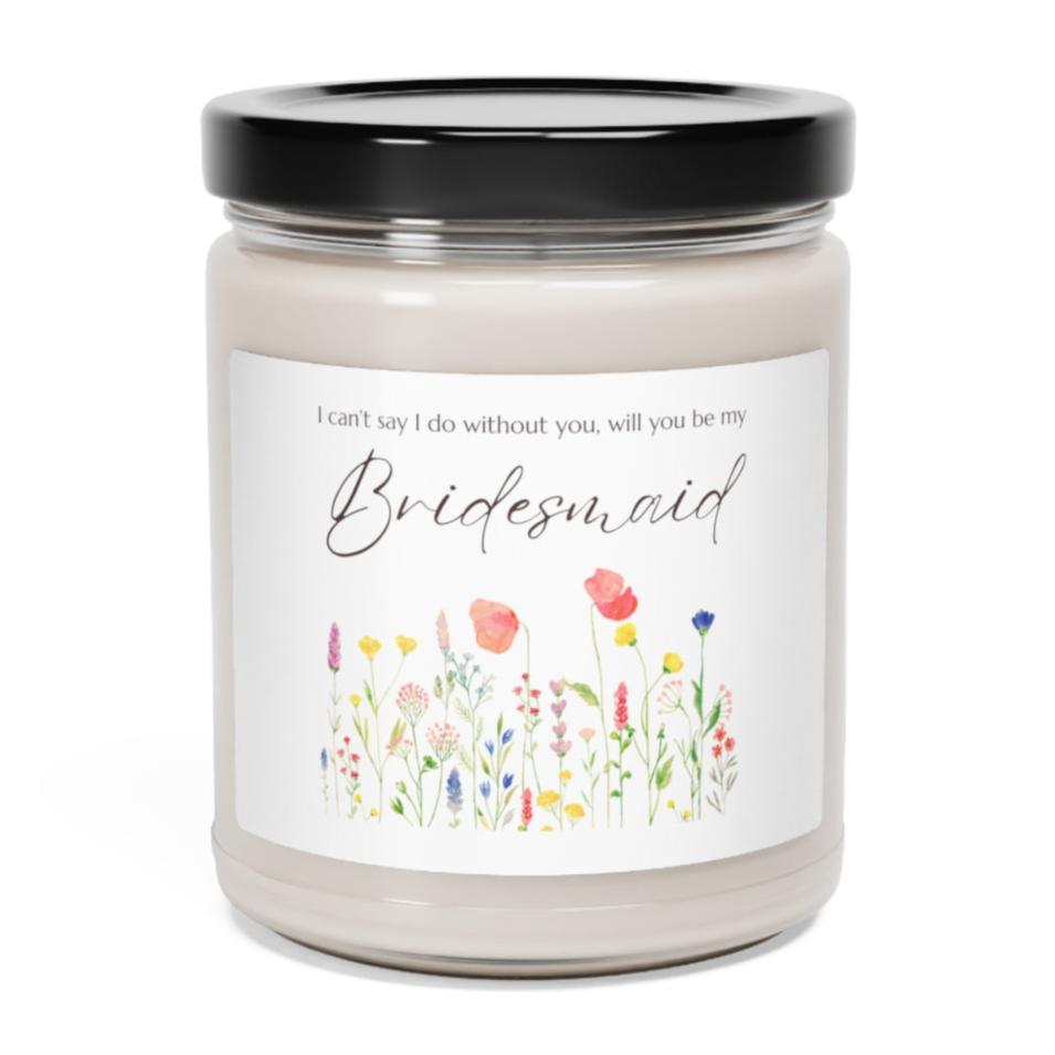 A picture of a glass jar of our lit soy candle that says: I cant say I do without you, will you be my Bridesmaid. There is a lovely painted style wild flower graphic underneath the sayings.