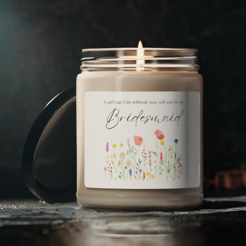 A picture of a glass jar of our lit soy candle that says: I cant say I do without you, will you be my Bridesmaid. There is a lovely painted style wild flower graphic underneath the sayings.