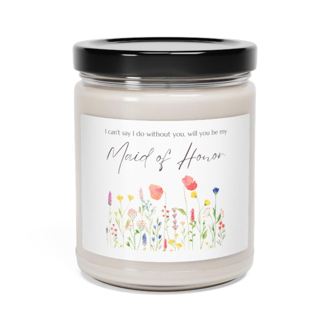 A picture of a glass jar of our lit soy candle that says: I cant say I do without you, will you be my Maid of Honor. There is a lovely painted style wild flower graphic underneath the sayings. The lid of the jar is black color.