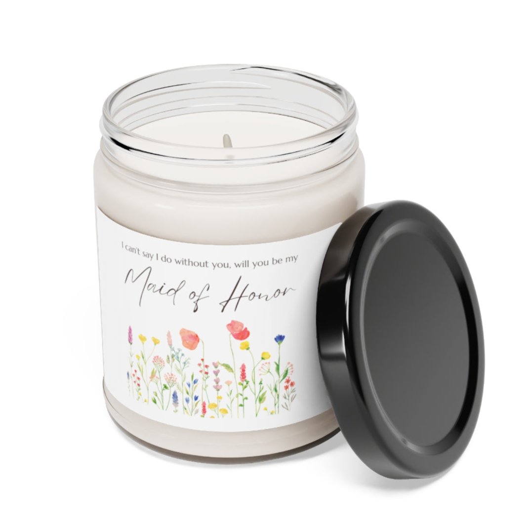 A picture of a glass jar of our lit soy candle that says: I cant say I do without you, will you be my Maid of Honor. There is a lovely painted style wild flower graphic underneath the sayings. The lid of the jar is black color.