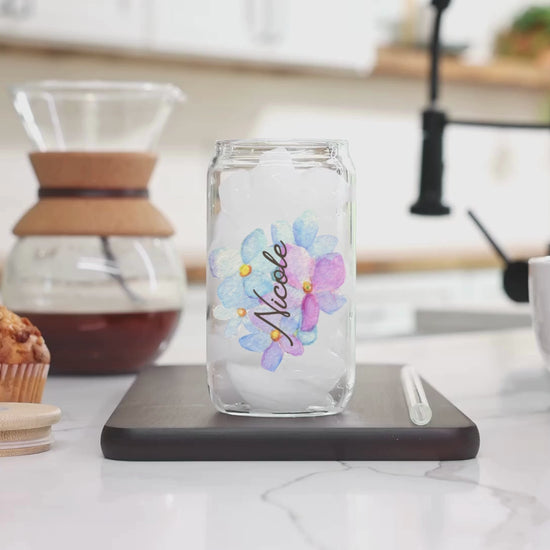 A video of milk being poured into the coffee mix inside our 16 Oz Sipper Glass with the name Nicole and pretty Blue Hydrangea Flower background. Name is customizable and there are 4 Flower background options to choose from.