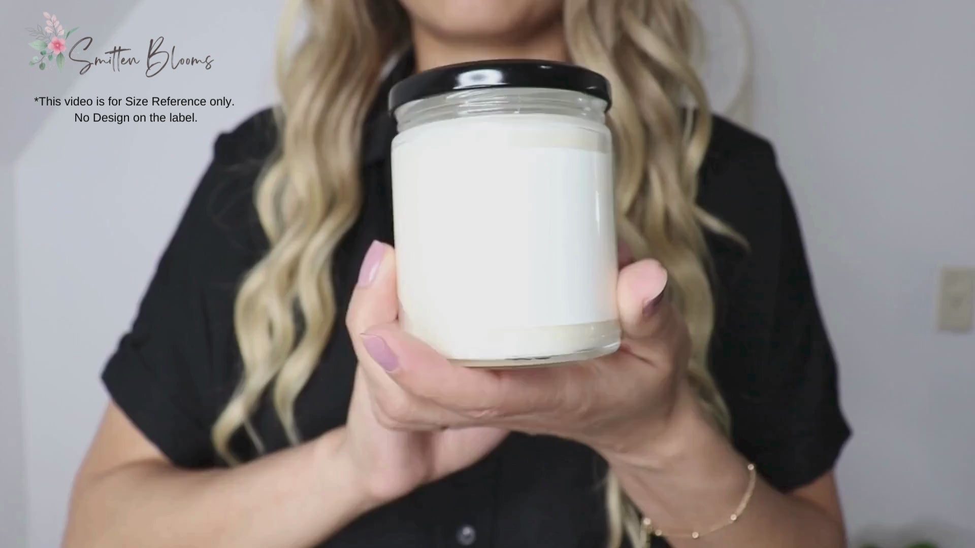 A video of a woman showing our 9 Oz soy wax candle for size reference only. There is design on this label. This video is to give customers an idea of the real life size of the candle jars. 